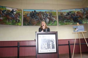 Sol Levenson’s artwork is visible behind Elisabeth Gordon, art program director, of Dartmouth Hitchcock hospital.