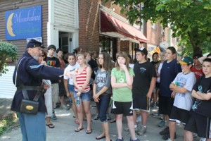 During a walking tour of the St. Albans Raid on June 11, Jim Fouts tells St. Albans Town eighth graders what happened during the infamous Confederate raid on St. Albans in 1864. The group stands where a man was shot and killed during the raid.