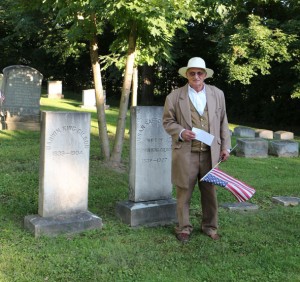 Mark Maloney place a marker and flag on the grave of Darwin K. Gilson.